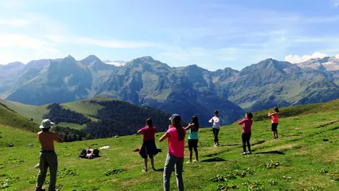 Un grup de persones practicant ioga en plena natura. (horitzontal)