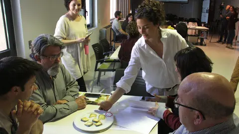 Pla general d'un grup de participants de la jornada t&radic;&reg;cnica sobre el formatge artes&radic;&dagger; del Pirineu a la cuina, a punt de valorar un dels formatges que els porta la directora cient&radic;&ne;fica de la Fundaci&radic;&ge; Al&radic;&ne;cia, Elena Roure, el 20 de mar&radic;&szlig; de 2019 (Horitzontal).
