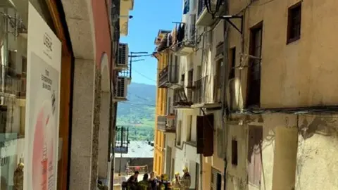 Pla general de l'edifici afectat pel foc a Puigcerd&agrave; i bombers treballant al carrer. El 16 de juny de 2019. (Vertical)