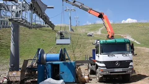 Pla de detall de les obres de prolongaci&oacute; del telecabina de la Molina on es veuen dos operaris treballant en el cablejat del remuntador, el 3 de juliol de 2019 (Horitzontal).
