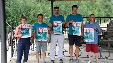 Imatge dels organitzadors de la Fira del Ferro d'Alins, al Pallars Sobir&agrave;, amb el cartell promocional. Imatge del 4 de juliol del 2018. (horitzontal)