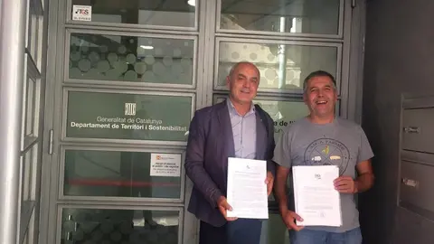 Representants de Joves Agricultors i Ramaders de Catalunya (JARC) i Uni&oacute;n de Agricultores y Ganaderos de Arag&oacute;n (UAGA-COAG) mostrant l'escrit que han presentat al departament de Territori de la Generalitat el 2 d'agost del 2019. (horitzontal)
