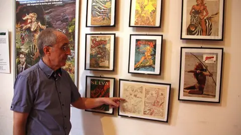 Pla mitj&agrave; del cin&egrave;fil i col&middot;leccionista Josep Benavent assenyant un dels c&ograve;mics en 3D de l'exposici&oacute; 'Herois i superherois'. Imatge del 6 d'agost de 2019 (Horitzontal).