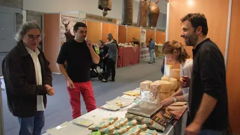 Pla general d'un dels expositors de formatge de la Fira de Formatges Artesans del Pirineu que acull la Seu d'Urgell, fent degustar el producte a alguns visitants, el 19 d'octubre de 2018 (Horitzontal).