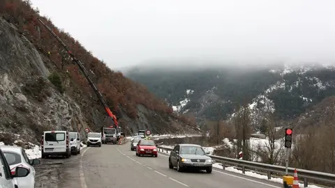 Pla general de diversos vehicles circulant en pas alternatiu regulat amb sem&radic;&dagger;fors a l'N-260 al Pont de Bar (Alt Urgell) i una grua que porta malla al punt on aquest dijous s'ha produ&radic;&Oslash;t una esllavissada. Imatge del 24 de gener de 2020 (Horitzontal).