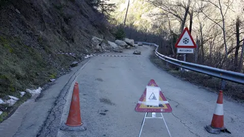 Pla general d'un senyal de carretera tallada al punt on han caigut diverses roques a la cal&ccedil;ada, a la carretera local que va des de l'N-145 a diversos nuclis del municipi de les Valls de Valira (Alt Urgell). Imatge del 5 de febrer de 2020 (Horitzontal).