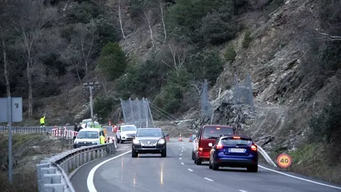 Pla general on es veuen cotxes aturats i d'altres circulant en pas alternatiu pel punt de la C-13 on aquest divendres es va produir una esllavissada que va obligar a tallar la carretera. Imatge del 29 de desembre de 2019 (Horitzontal).