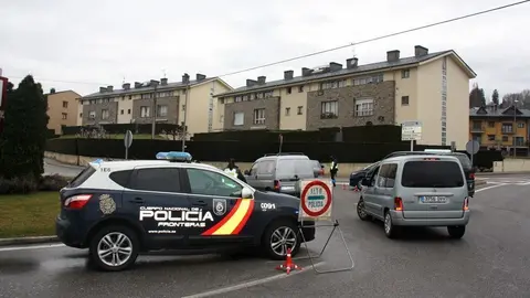 Pla general on es veu un vehicle de la policia espanyola i diversos cotxes aturats a la rotonda d'acc&eacute;s a Puigcerd&agrave; des de la Guingueta d'Ix, a l'Alta Cerdanya, o la carretera de l'enclavament de Ll&iacute;via. Imatge del 17 de mar&ccedil; de 2020 (Horitzontal).