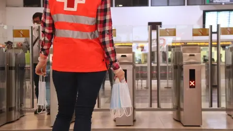 Pla tancat d'una volunt&agrave;ria de la Creu Roja amb diverses mascaretes a l'estaci&oacute; de Sants de Barcelona. Imatge del 14 d'abril de 2020. (Horitzontal)