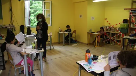 Pla general d'una professora amb mascareta i un grup d'alumnes distanciats entre ells en una de les aules de l'escola Jordi Pere Cerd&agrave; de Sallagosa, a la banda administrativament francesa de la Cerdanya. Imatge del 15 de maig de 2020 (Horitzontal).
