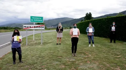 Pla general de diverses integrants de la Plataforma Docents Substituts de Cerdanya mostrant el manifest i material de difusi&oacute; al l&iacute;mit provincial entre Lleida i Girona situat al terme de Prats i Sansor. Imatge del 10 de juny de 2020 (Horitzontal).