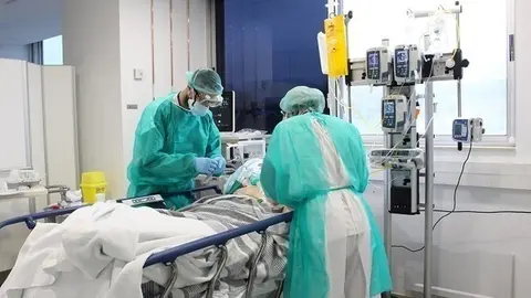 Pla mitj&agrave; de dos metges tenint cura d'un pacient amb coronavirus aquest dissabte 18 d'aril de 2020 a l'hospital Trueta. (Horitzontal)