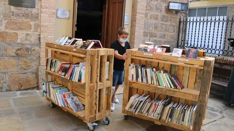 Un jove voluntari obrint la botiga del Jard&iacute; dels Llibres a la Pobla de Segur el 9 de juliol del 2020. (horitzontal)