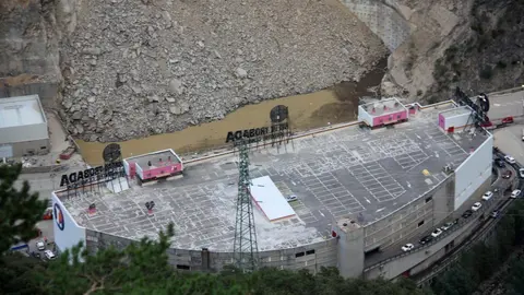 Pla de detall d'una part de l'esllavissada que s'ha produit a la carretera CG-1 d'Andorra vista des de la zona de la Borda Sabat&eacute; i on es veu un forat ple d'aigua i part del sostre del centre comercial Punt de Trobada, el 10 d'agost de 2019 (Horitzontal).