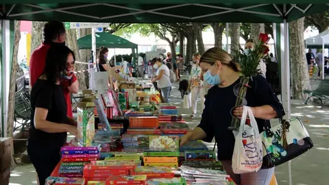 Una dona amb un ram de roses a una parada de llibres de la Seu d'Urgell el 23 de juliol del 2020. (horitzontal)
