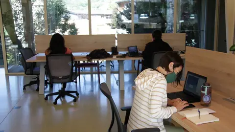 Pla obert de l'interior de l'espai de 'coworking' de Prullans (Cerdanya) on es veuen diverses persones treballant-hi. Imatge del 25 d'agost de 2020 (Horitzontal).