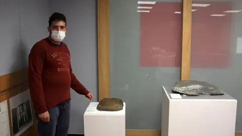 Pla americ&agrave; del director del Museu de Ll&iacute;via, Gerard Cunill, mostrant algunes de les pissarres gravades del castell de Ll&iacute;via que es poden veure en el marc d'una exposici&oacute; sobre l'art rupestre de Cerdanya. Imatge del 7 d'octubre de 2020 (Horitzontal).