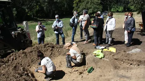 Pla obert de dos arque&ograve;legs treballant en l'excavaci&oacute; d'una fossa de la Guerra Civil a Sorpe, a l'Alt &Agrave;neu (Pallars Sobir&agrave;), i familiars de les v&iacute;ctimes que hi hauria enterrades mirant-ho al seu costat, el 2 de setembre de 2020 (Horitzontal).