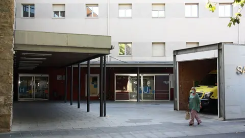 Pla obert on es veu una de les entrades del Sant Hospital de la Seu d'Urgell i una persona passant pel davant amb mascareta, el 20 d'agost de 2020 (Horitzontal).