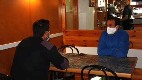 Pla mitj&agrave; de dos clients asseguts en una taula d'un bar del nucli d'Adrall, a Ribera d'Urgellet (Alt Urgell), en el primer dia de reobertura del sector de la restauraci&oacute;. Imatge del 23 de novembre de 2020 (Horitzontal).