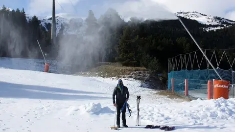 Pla general del director d'Altitud Extrem, Xavi Fanlo, preparant les raquetes per una excursi&oacute; guiada a la base de l'estaci&oacute; de La Molina (Cerdanya) i on es veu un can&oacute; produint neu. Imatge del 2 de desembre de 2020 (Horitzontal).