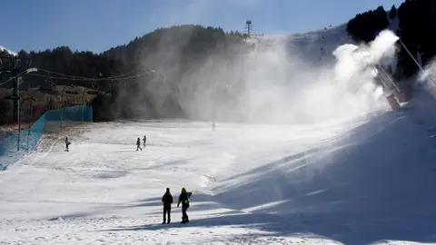 Pla obert on es veu una de les pistes d'esqu&iacute; de La Molina (Cerdanya), amb els canons produint neu i algunes persones passejant-hi. Imatge del 2 de desembre de 2020 (Horitzontal).