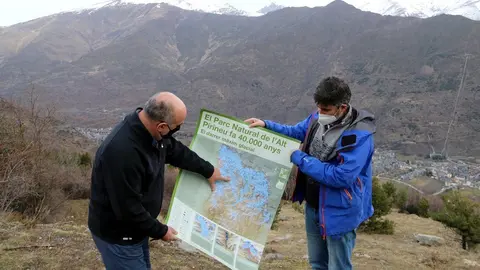 Pla general de dos persones mostrant el p&ograve;ster sobre la glacera de la Noguera Pallaresa que ha editat el Parc Natural de l'Alt Pirineu. Imatge del 5 de febrer del 2021. (horitzontal)