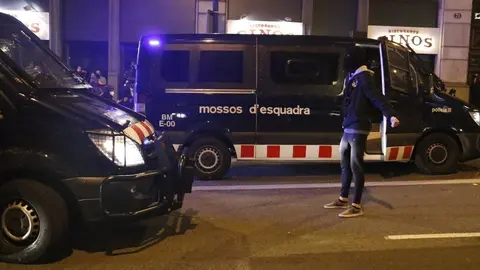 Un manifestant es planta davant de furgonetes dels Mossos d'Esquadra durant unes protestes contra l'empresonament del cantant Pablo Hasel el 17 de febrer del 2021 a Barcelona. Pla general. (Horitzontal)