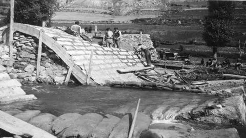 Pla general d'una panor&agrave;mica de la construcci&oacute; d'una central hidroel&egrave;ctrica a les Valls d'&Agrave;neu. (horitzontal)