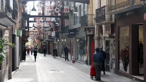 Pla obert on es veuen algunes persones passejant pel carrer Major de Puigcerd&agrave;, amb menys aflu&egrave;ncia de gent pel confinament perimetral de la Cerdanya. Imatge del 29 de desembre de 2020 (Horitzontal).