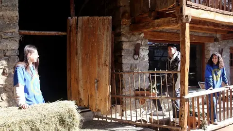 Pla obert de la Maragda Farr&agrave;s, a l'esquerra, parlant amb dos amics a la casa de M&uacute;sser, a Lles de Cerdanya, que s'est&agrave; rehabilitant per acollir el Taller d'Entorns dedicat a la creaci&oacute; art&iacute;stica. Imatge del 16 de mar&ccedil; de 2021 (Horitzontal).