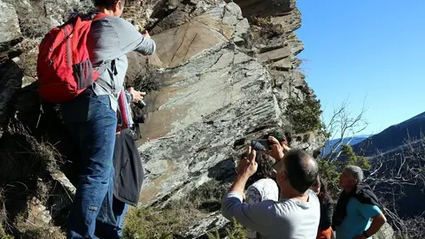 Imatge de ve&iuml;ns observant les roques on estan esculpits els gravats a la vall d'&Agrave;ssua. Imatge del 3 de gener del 2019. (horitzontal)
