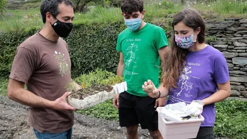 Pla mig de dos representants del col&middot;lectiu Eixarcolant entregant plantes a un voluntari que les plantar&agrave; a l'hort. Imatge del 4 de maig del 2021. (horitzontal)