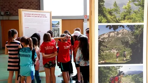 Pla de detall d'un grup d'escolars visitant la mostra 'Hist&ograve;ries i Camins. Passeig literari pels camins pirinencs' el 21 de maig del 2021. (Horitzontal)