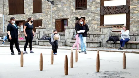Primer pla de les bitlles pallareses i al fons una jugadora preparada per fer una tirada. Imatge del 30 de maig del 2021. (horitzontal)