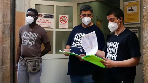 Diverses persones registren les persones sense llar que es vacunen al centre obert d'Arrels. Imatge del 3/6/2021 (horitzontal)