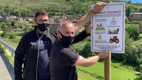 Pla mitj&radic;&dagger; del gerent i el president de la Federaci&radic;&ge; Ra&radic;&szlig;a Bruna dels Pirineus (Februpi), Mart&radic;&ne; Orriols i Joan Noguera, mostrant el cartell que enganxaran a Prullans (Cerdanya) per la campanya "Atenci&radic;&ge; visitants", el 21 de juny de 2021. (Horitzontal)