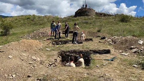 Pla general de l'equip d'arque&ograve;legs treballant als sondejos que han fet a l'entorn del castell de Ll&iacute;via, amb el director de les excavacions de 'Iulia Libica', C&egrave;sar Carreras, explicant la tasca duta a terme. Imatge del 15 de juliol de 2021. (Horitzontal)