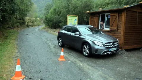 Pla obert de la caseta i del vigilant que controla l'acc&eacute;s als aparcaments que donen acc&eacute;s a la Pica d'Estats i un vehicle sortint de la zona, el 31 de juliol del 2021. (Horitzontal)