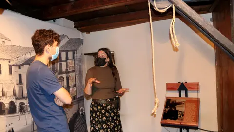 Pla general de dos persones visitant la mostra 'Se'n parlave...i n'hi havie'  l'apartat de tortures. Imatge del 10 d'agost del 2021. (Horitzontal)