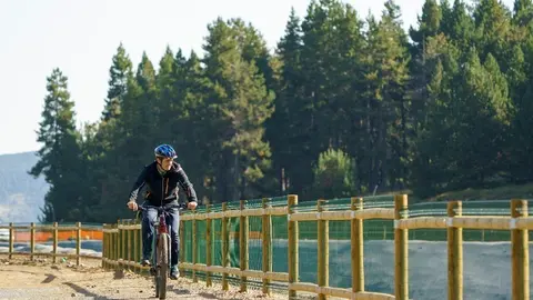 Pla obert d'un treballador de l'estaci&oacute; de La Molina (Cerdanya) fent &uacute;s d'una bicicleta el&egrave;ctrica per despla&ccedil;ar-se dins l'estaci&oacute;. Imatge del 15 de setembre de 2021. (Horitzontal)