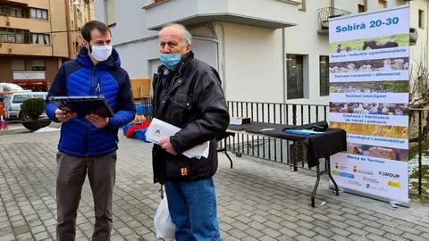 Pla general d'un t&egrave;cnic del programa Sobir&agrave; 20-30 fent una enquesta al carrer el dia del mercat de Sort el 13 de gener del 2021. (horitzontal)