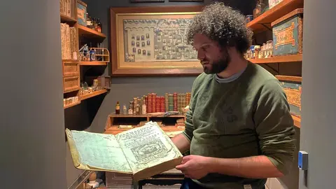Pla mitj&radic;&dagger; del director del Museu de Ll&radic;&ne;via, Gerard Cunill, mirant un dels volums del fons bibliogr&radic;&dagger;fic de l'antiga farm&radic;&dagger;cia Esteva a les instal&not;&sum;lacions de l'equipament. Imatge del 16 de novembre de 2021. (Horitzontal)