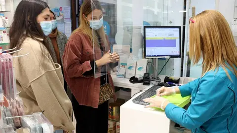 Pla mitj&agrave; de diverses noies esperant el torn per fer-se un test d'ant&iacute;gens en una farm&agrave;cia, el 28-12-21 (Horitzontal).