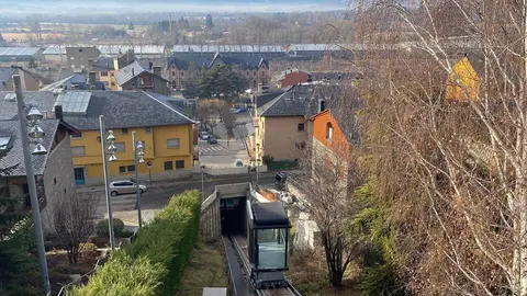Pla obert on es veu l'ascensor inclinat de Puigcerd&agrave; al mig del seu recorregut entre la pla&ccedil;a de l'estaci&oacute; i el carrer Raval de les Monges, al centre hist&ograve;ric del municipi. Imatge del 4 de gener de 2022. (Horitzontal).