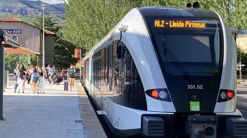 Pla obert on es pot veure el tren de la l&radic;&ne;nia de la Pobla a l'arribada a l'estaci&radic;&ge; de la Pobla de Segur amb alguns turistes acabats de baixar, l'agost de 2021. (Horitzontal)