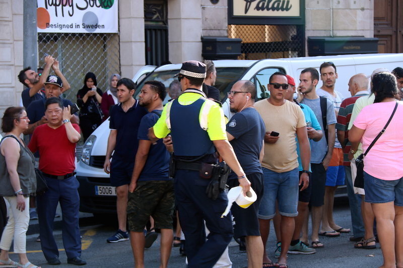 Un policia indica als ciutadans que s'allunyin pel carrer Pelai de Barcelona, el 17 d'agost de 2018 (horitzontal)