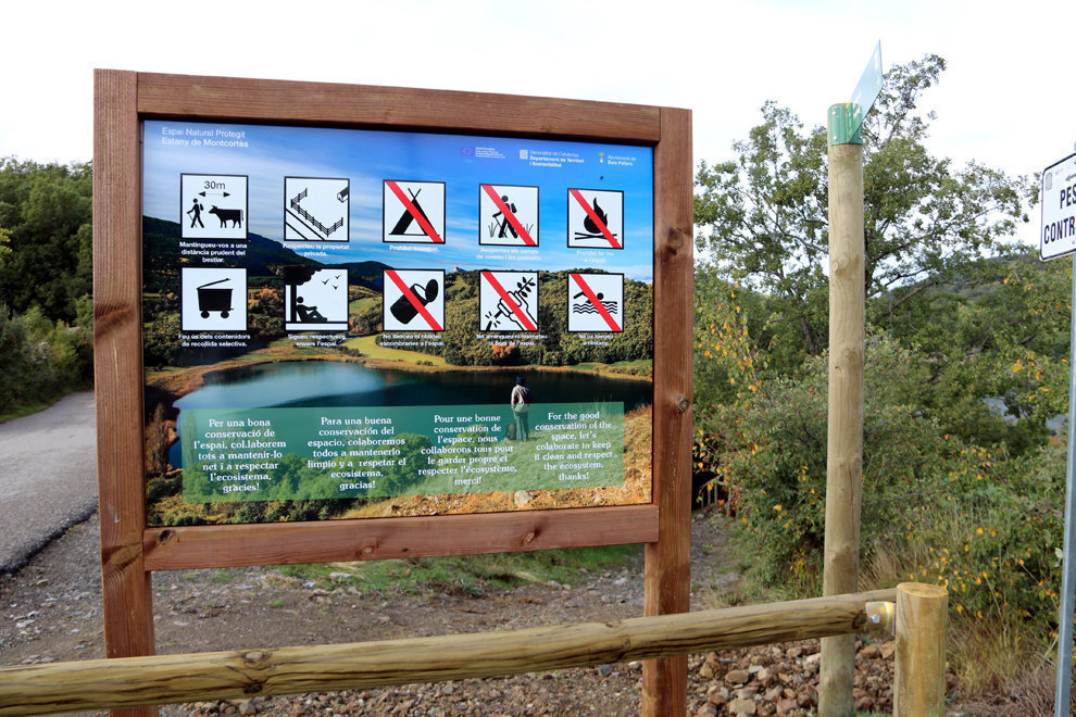 Primer pla d'un rètol que indica que el bany queda prohibit a l'estany de Montcortés, al Pallars Sobirà. Imatge del 18 d'octubre del 2018. (horitzontal)
