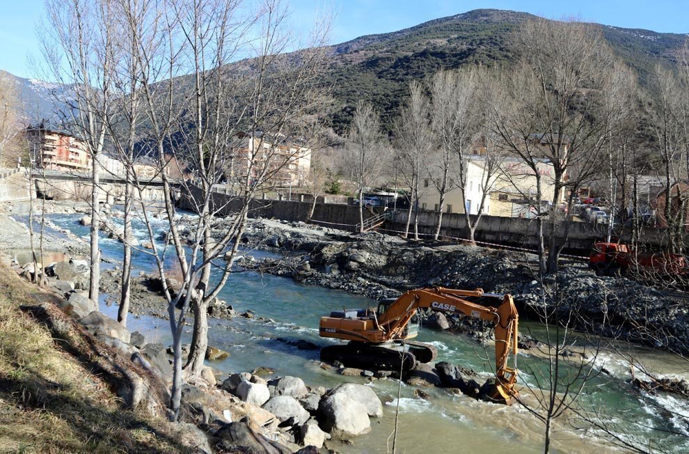 Pla general d'una màquina excavadora treballant al mig del riu Noguera Pallaresa al seu pas per Sort el 6 de febrer del 2019. (horitzontal)