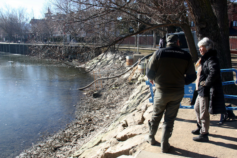Pla general de la regidora de Medi Ambient de l'Ajuntament de Puigcerdà, Marta Rufiandis, amb un dels efectius dels Agents Rurals al costat del llac, que s'està buidant per dur a terme una maniobra ambiental. Imatge del 14 de gener de 2020 (Horitzontal).